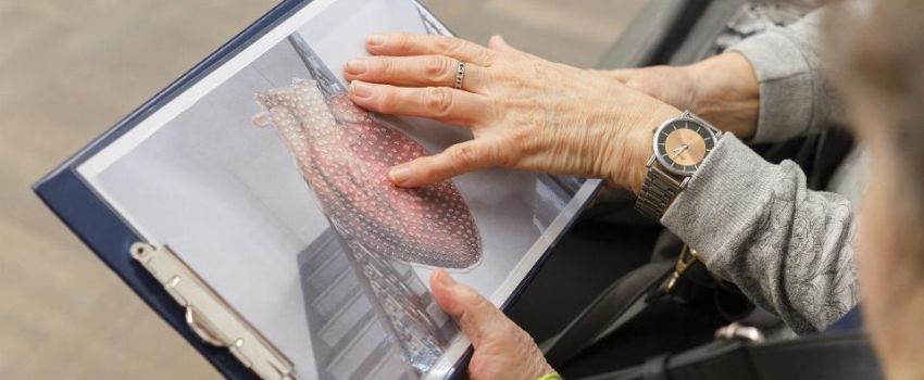 w centrum kadru dłoń dotykająca tyflografikę
