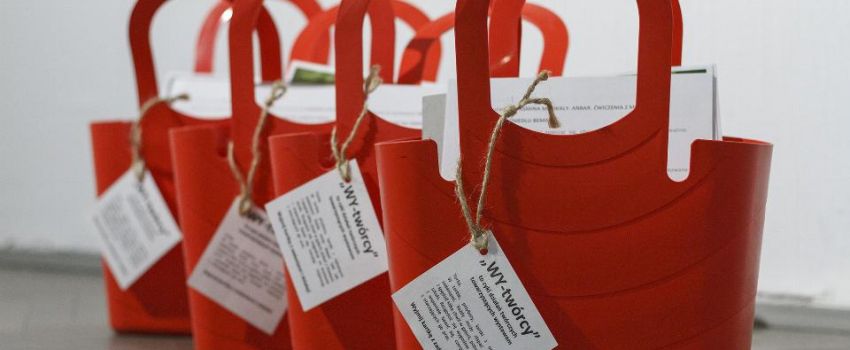 Czerwone, plastikowe torby WY-TWÓRCY. Stoją na podłodze