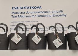 Na ladzie stoją szare koszyki z materiałami i zadaniami. W tle napis: Eva Kotatkowa "Maszyna do przywracania empatii".