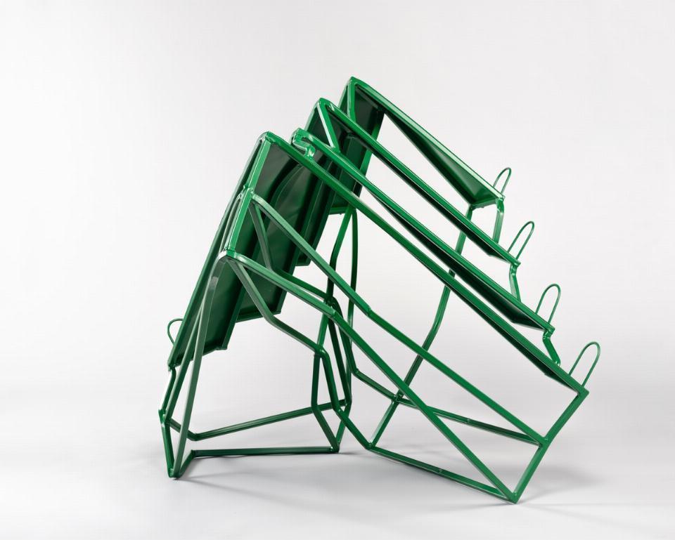 Abstrakcyjna, stalowa konstrukcja w kolorze zielonym. Ma połysk. Umieszczona na białym tle.