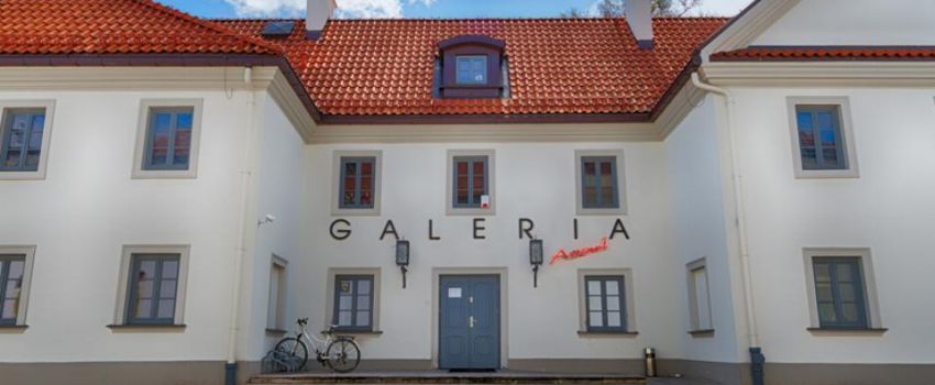 budynek Galerii Arsenał, jasna elewacja, czerwony dach, niebieskie niebo