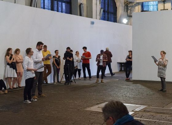 Ogólny widok ludzi w przestrzeni hali elektrowni Galerii Arsenał. Ściany białe