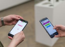 w centralnej części zdjęcia trzymane przez dwie różne osoby dwa telefony, na których widoczne jest logo gry SEPPO